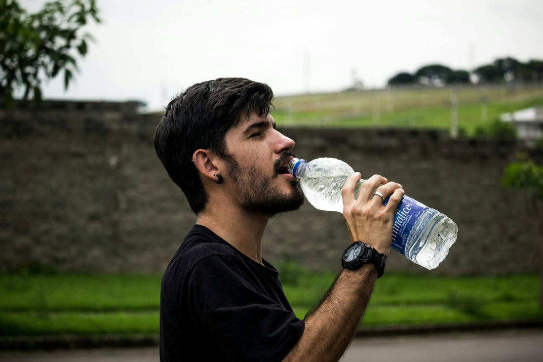 mydoxa homme s'hydratant en buvant une bouteille d'eau